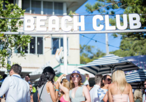 People dance under a beach club sign in Sydney.